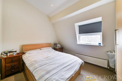 伦敦Cosy Caledonian Road Apartment, Nearby Tube and Restaurants的一间小卧室,配有床和窗户