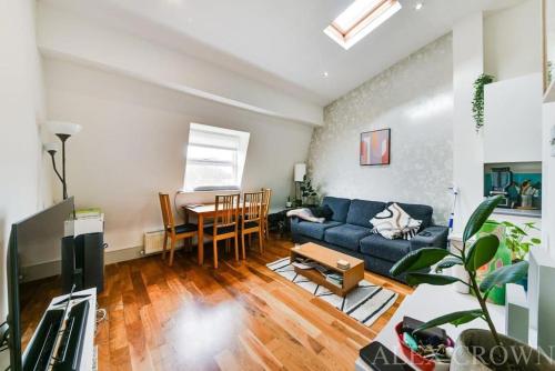 伦敦Cosy Caledonian Road Apartment, Nearby Tube and Restaurants的客厅配有蓝色的沙发和桌子