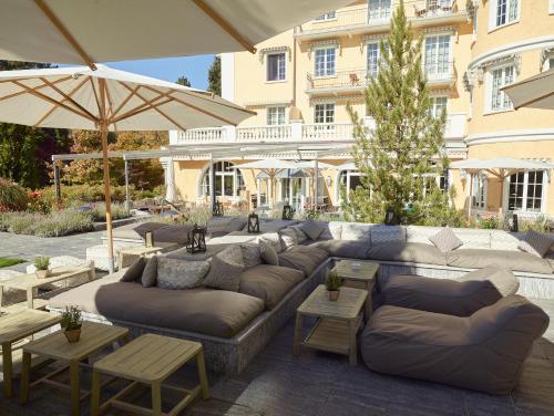 格施塔德乐格兰德贝尔维尤酒店的一个带沙发和桌子及遮阳伞的庭院
