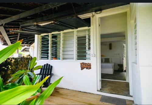 维拉港Banana Bay Beach Club的白色房子的敞开门,带长凳