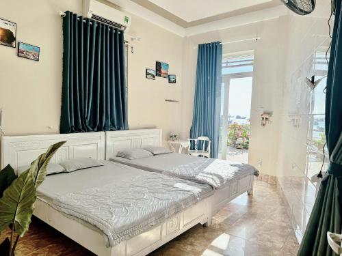 惹岛Homestay tiên tri 01的一间卧室配有白色的床和蓝色窗帘