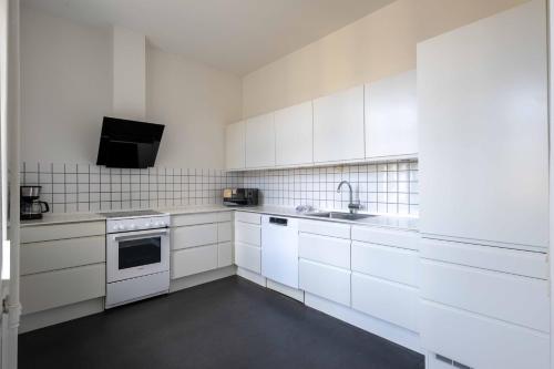 哥本哈根3 Bedroom Flat in Lovely Area的白色的厨房配有白色橱柜和水槽