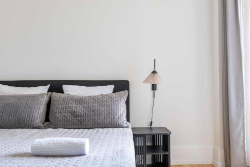 哥本哈根3 Bedroom Flat in Lovely Area的白色卧室配有床和灯