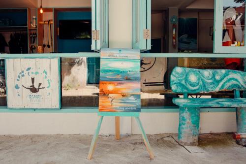 古莉Ocean Pearl Maldives at Gulhi Island的商店窗户前的标志,带椅子