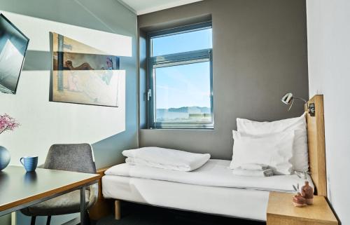 斯塔万格佛勒斯时尚酒店的客房设有床、书桌和窗户。