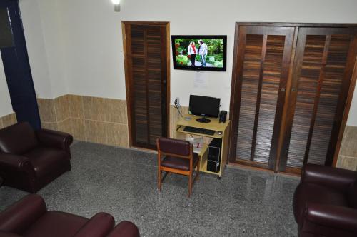 里约热内卢公园酒店的客厅配有椅子和墙上的电视