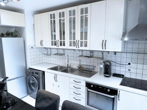 圣但尼Le jardin du stade by UTA HOUSE的厨房配有白色橱柜、水槽和洗碗机。