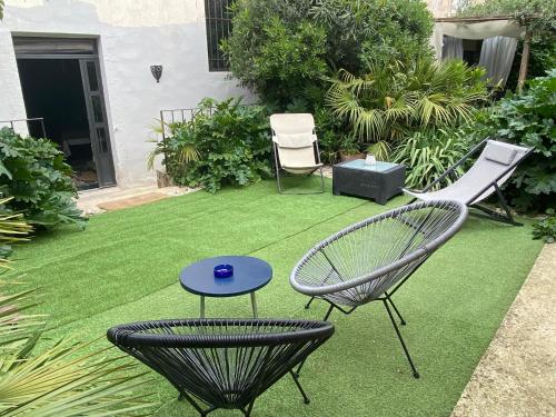 尼翁Les Lauriers Duplex centre ville avec jardin的庭院,草坪上配有两把椅子和一张桌子