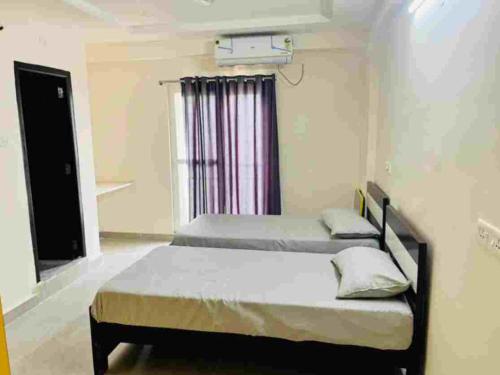 海得拉巴Stay In Hotels and Resorts的一间卧室设有两张床和窗户。