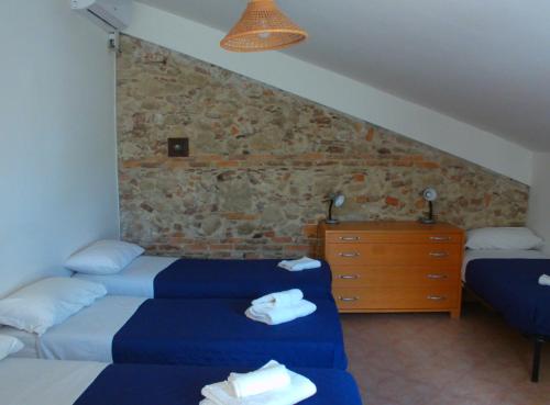 斯奎拉切Oasi del Governatore的一间卧室设有两张床和石墙