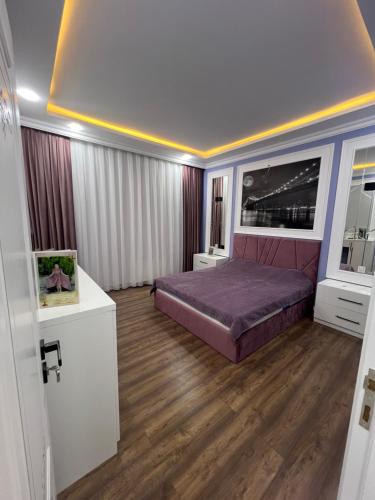 Zağulba BağlarıMy_willa_Buzovna的一间卧室配有紫色的床,铺有木地板