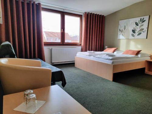 Moravský Žižkov玛德里奇旅馆的酒店客房配有一张床铺和一张桌子。