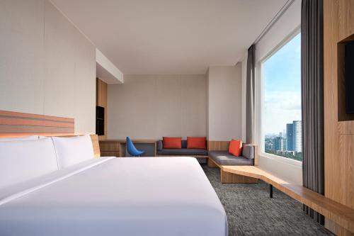 雅加达Aloft South Jakarta的酒店客房设有一张床和一个大窗户