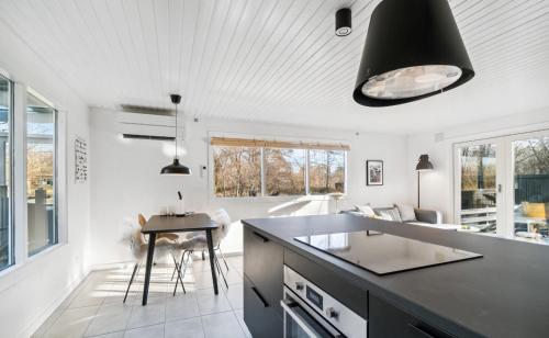 维斯特索马肯Lovely Summer House With Bornholm Atmosphere,的厨房配有黑色台面和桌子