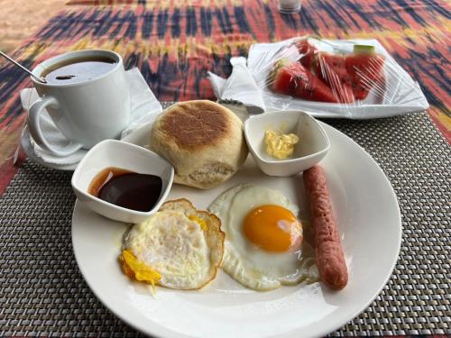 莫希Janibichi Adventures hostel的包括鸡蛋香肠和咖啡的早餐食品