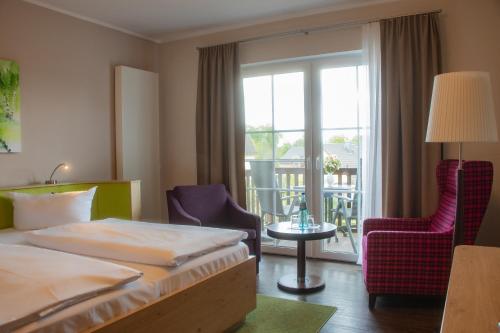 布尔格Hotel Bleske im Spreewald的酒店客房带一张床、椅子和一个阳台