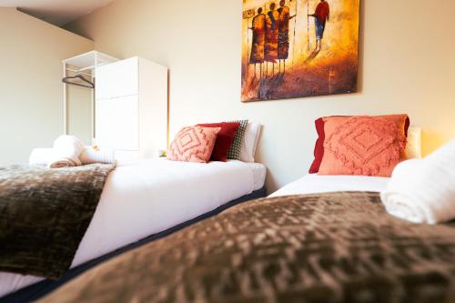 蒙斯Lets Relax - Terre d'Afrique的一间卧室设有两张床,墙上挂着一幅画