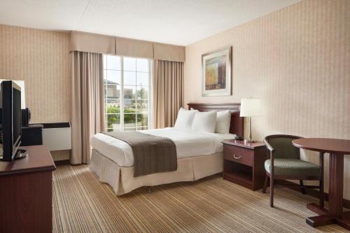 布兰特福德布兰特福德戴斯酒店的酒店客房配有一张床、一张书桌和一台电视。