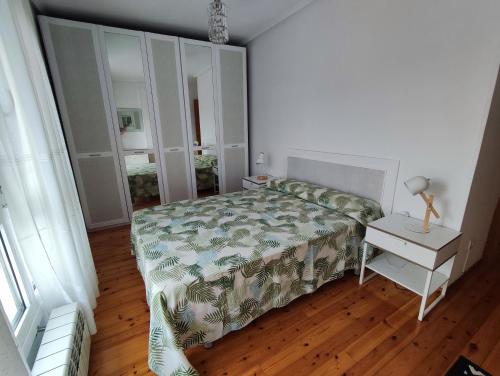 科林德雷斯Laredo-Colindres的一间卧室配有一张床和一张桌子及床头柜