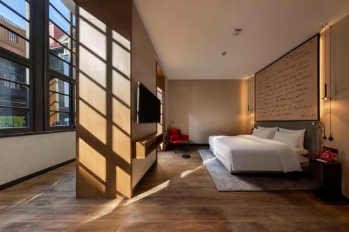 第比利斯Radisson RED Tbilisi的一间卧室设有一张大床和一个大窗户