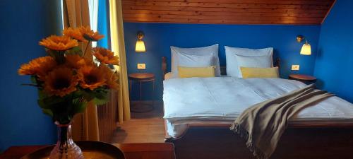 OtruševecGreenHouse s bazenom的蓝色的卧室,配有一张床和花瓶