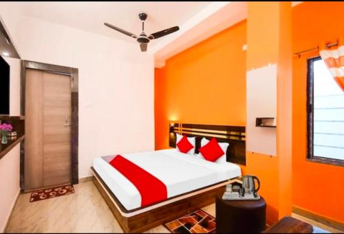 SaluaOyo chinar haven的一间卧室拥有橙色的墙壁,配有一张带红色枕头的床。