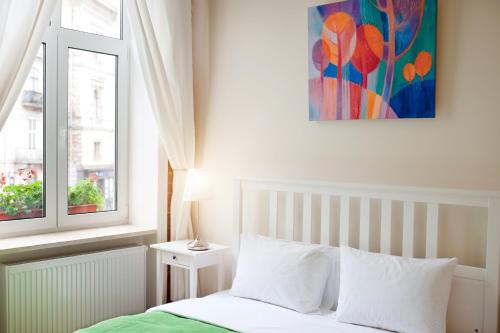 利沃夫达尼罗宾馆的卧室配有一张床,墙上挂有绘画作品