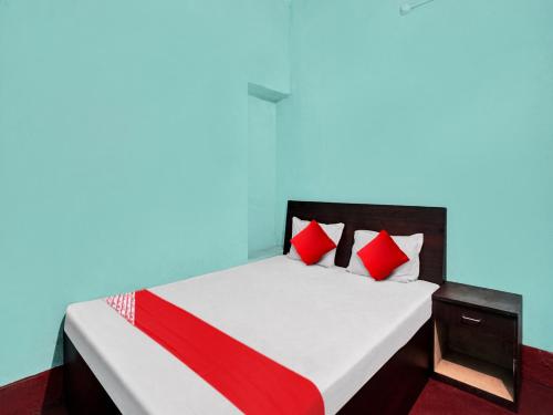 巴特那OYO Flagship New Pushpanjali Guest House的一间卧室配有红色枕头的床