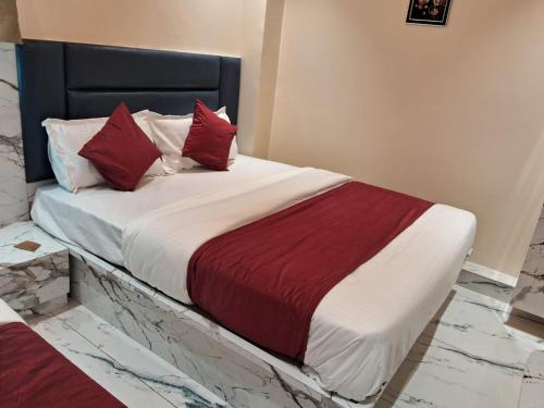 艾哈迈达巴德HotelMeetPalace的一间卧室配有一张带红色枕头的大床