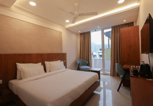 哈里瓦Arjun - A boutique hotel的酒店客房设有一张床和一个阳台。