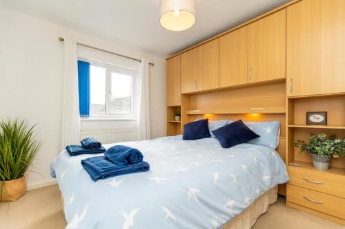 拉内利Comfortable and Spacious Superb Holiday Home in Llanelli, Dog Friendly的一间卧室配有一张大床,上面有蓝色的毛巾