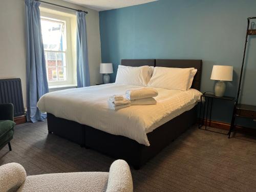 Temple Sowerby国王武器寺索尔比宾馆的一间卧室配有一张床,上面有两条毛巾