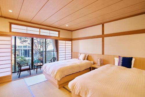 青森椿馆日式旅馆的带窗户的客房内的两张床