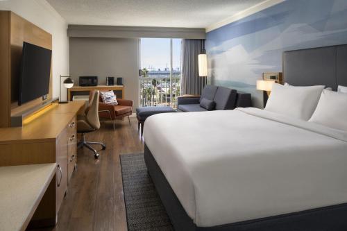 长滩长滩市中心万豪酒店的酒店客房设有一张大床和一台电视。