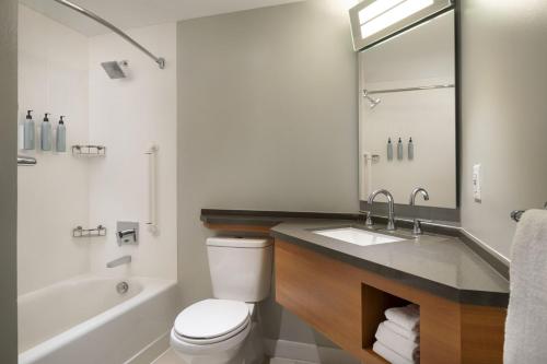 长滩长滩市中心万豪酒店的浴室配有卫生间、盥洗盆和浴缸。