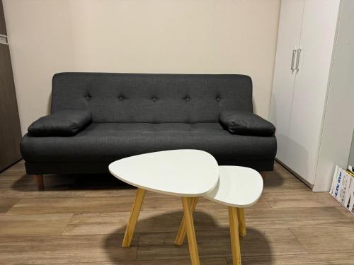 布宜诺斯艾利斯2 ambientes moderno y muy bien ubicado的客厅配有黑色沙发和白色桌子