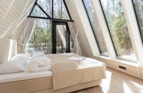 PillapaluKuuse elamusmajad的配有大窗户的客房内的一张床位