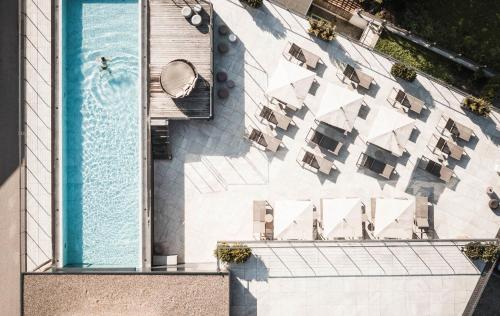 圣维吉利奥Excelsior Dolomites Life Resort的享有大楼游泳池的顶部景致