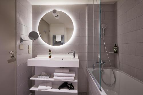 图卢兹Aparthotel Adagio Original Toulouse Centre La Grave的浴室配有盥洗盆、镜子和浴缸
