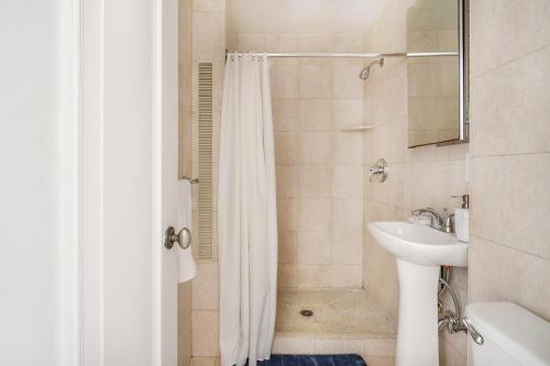 纽约73-1104 New Studio UWS Doorman Gym的浴室配有淋浴帘和盥洗盆。