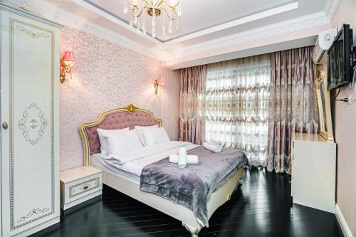 巴库Park Azure Deluxe Apartment By Baku Housing的一间卧室配有一张床和一个吊灯