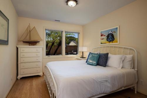 圣巴巴拉Casa Costera的卧室设有一张白色大床和一扇窗户。