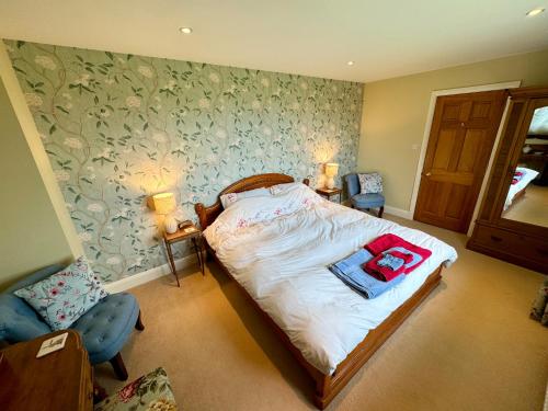 布拉克利Cockley Hill Farm Bed & Breakfast的一间卧室配有一张床和一把椅子