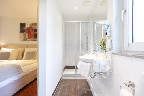 不莱梅Hotel Garden Bremen的白色的浴室设有水槽和一张床