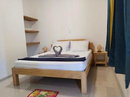 莫阿尔博阿Sambag Hideaway Bungalows的一间卧室配有一张带两个天鹅的床