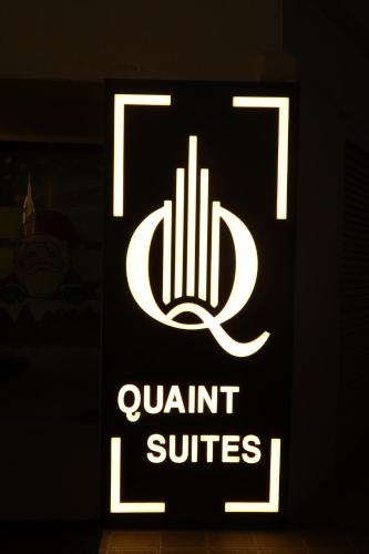 孟买Quaint Suites Hotel & Banquet的黑暗房间中高品质套房的标志
