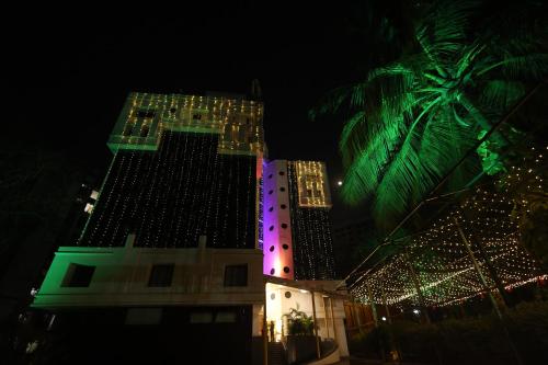 孟买Quaint Suites Hotel & Banquet的一座晚上有圣诞灯的建筑