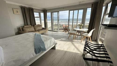 布鲁堡史特兰Oceansnest Guest House的一间卧室配有一张床,客厅配有桌子