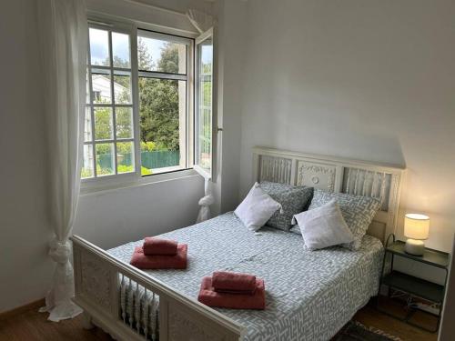 GaréoultLa Maison Bleue的一间卧室配有一张带两个红色毛巾的床