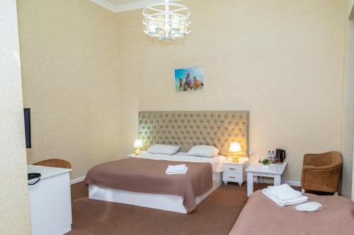 巴库Sahil Ark Hotel Baku的一间卧室配有一张大床和一个吊灯。